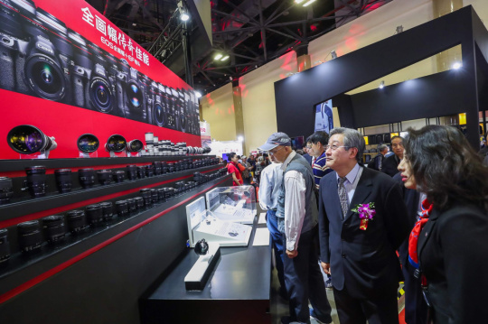 中国机械工业联合会执行副会长薛一平在佳能展台了解佳能EF镜头产品